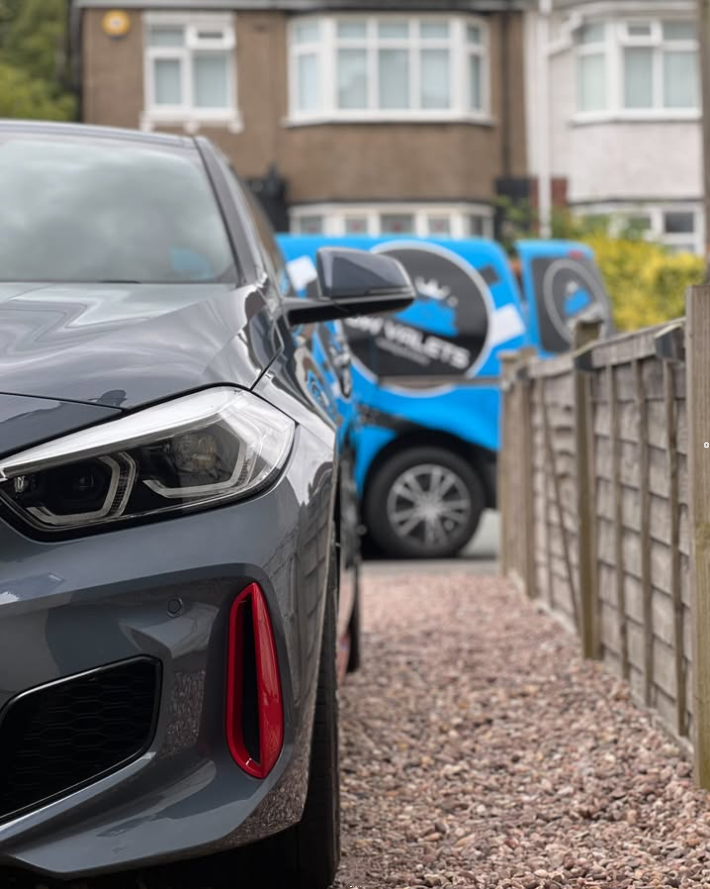 BMW headlight detail with the JW Valets van in the background